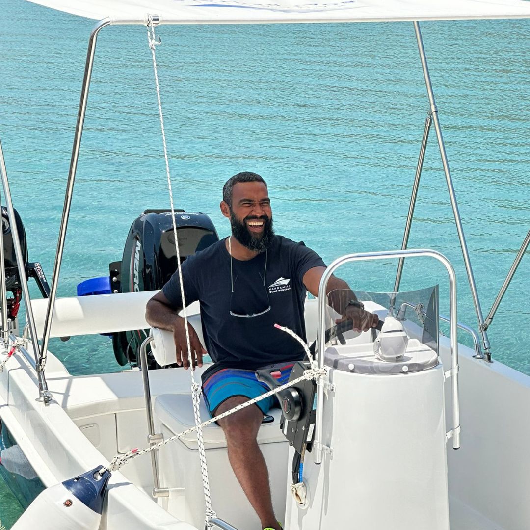 This is Ariel, one of our tea members, looking at the camera while sitting inside the "Delfinia" boat, at Kardamili Boat Harbor. Ariel is smiling.