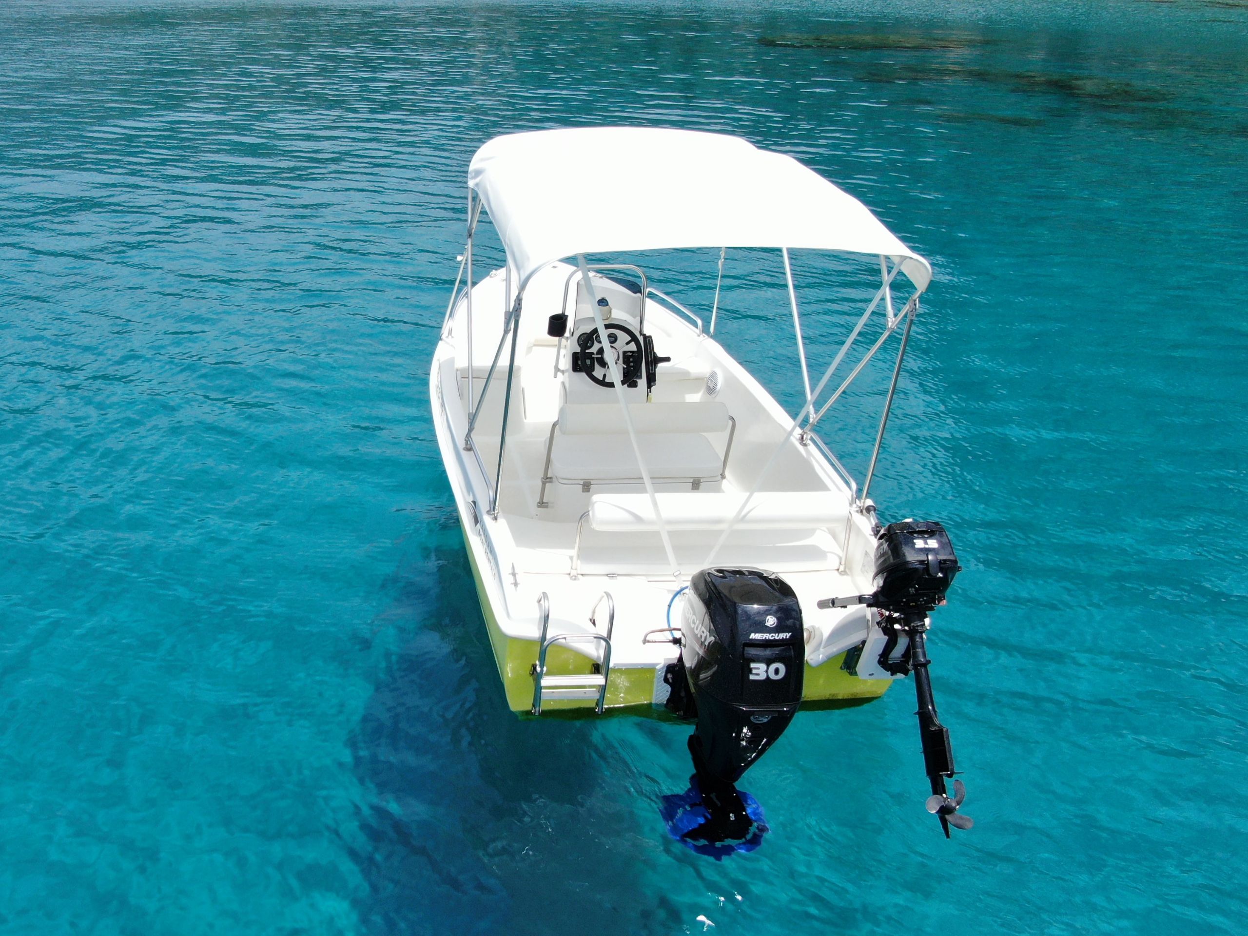 This is an image of our Kardamili Boat Rentals Ritsa boat in sea, in Mani. The boat is yellow and new.