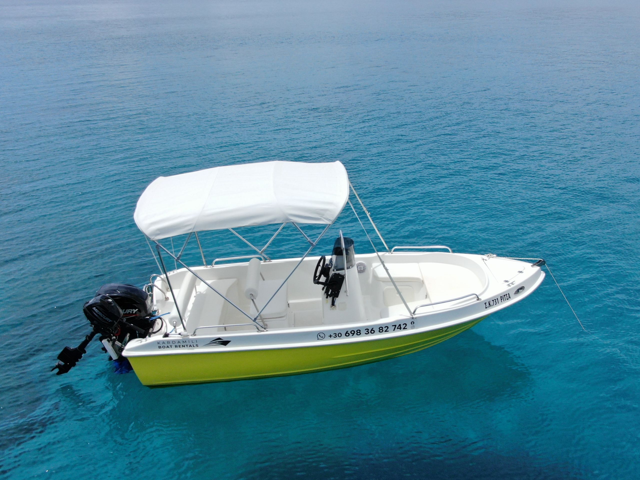 This is an image of our Kardamili Boat Rentals Ritsa boat in sea, in Mani. The boat is yellow and new.